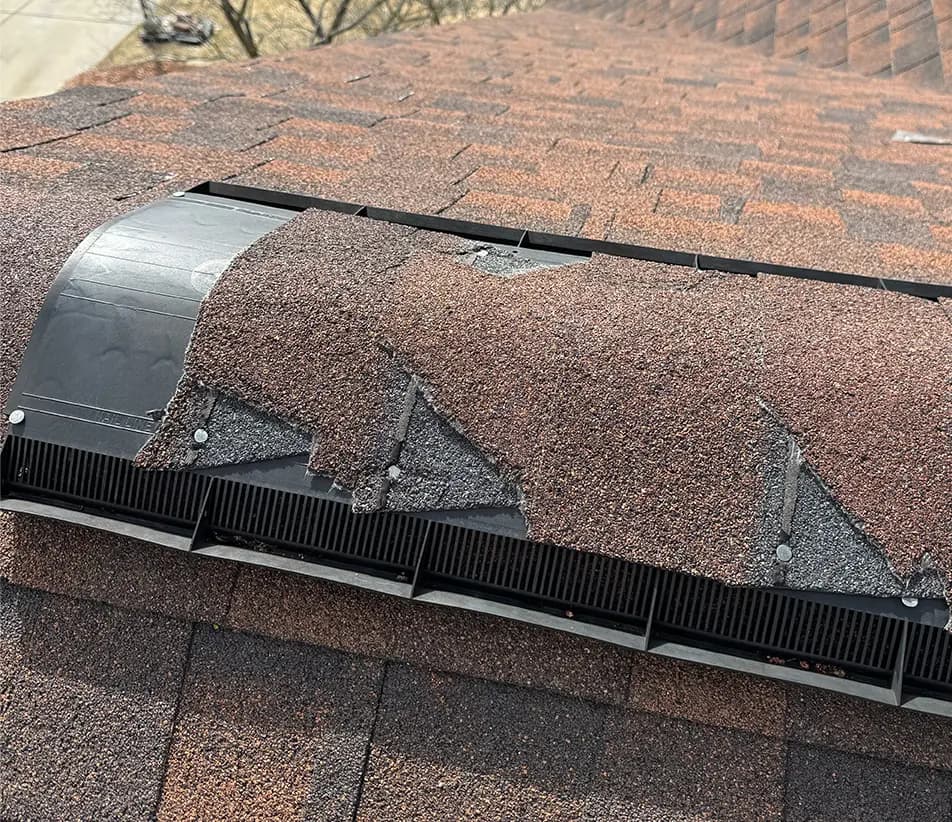 broken ridge cap shingles on a ridge vent