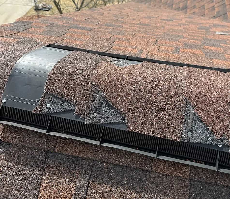 Broken Shingles - Michigan Roof Repair Services broken ridge cap shingles on a ridge vent
