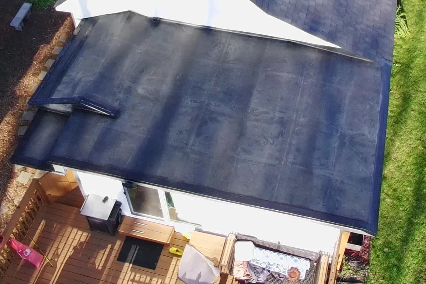 Drone view of a black EPDM rubber membrane roof installed by Roofing Army on a low-slope addition in Michigan