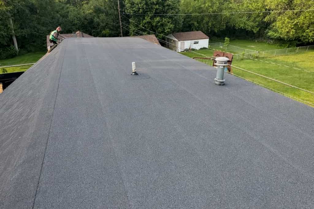 CertainTeed Flintlastic modified bitumen roof installed by Roofing Army on a low-slope Michigan home, crew member at the ridge