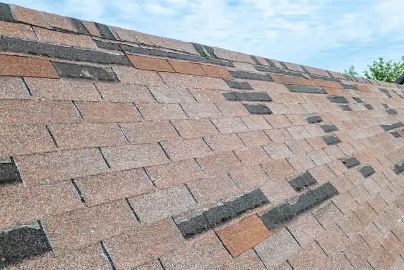 Storm Damage Services in Southeast Michigan - Roofing Army missing shingles on an asphalt roof in michigan from wind damage