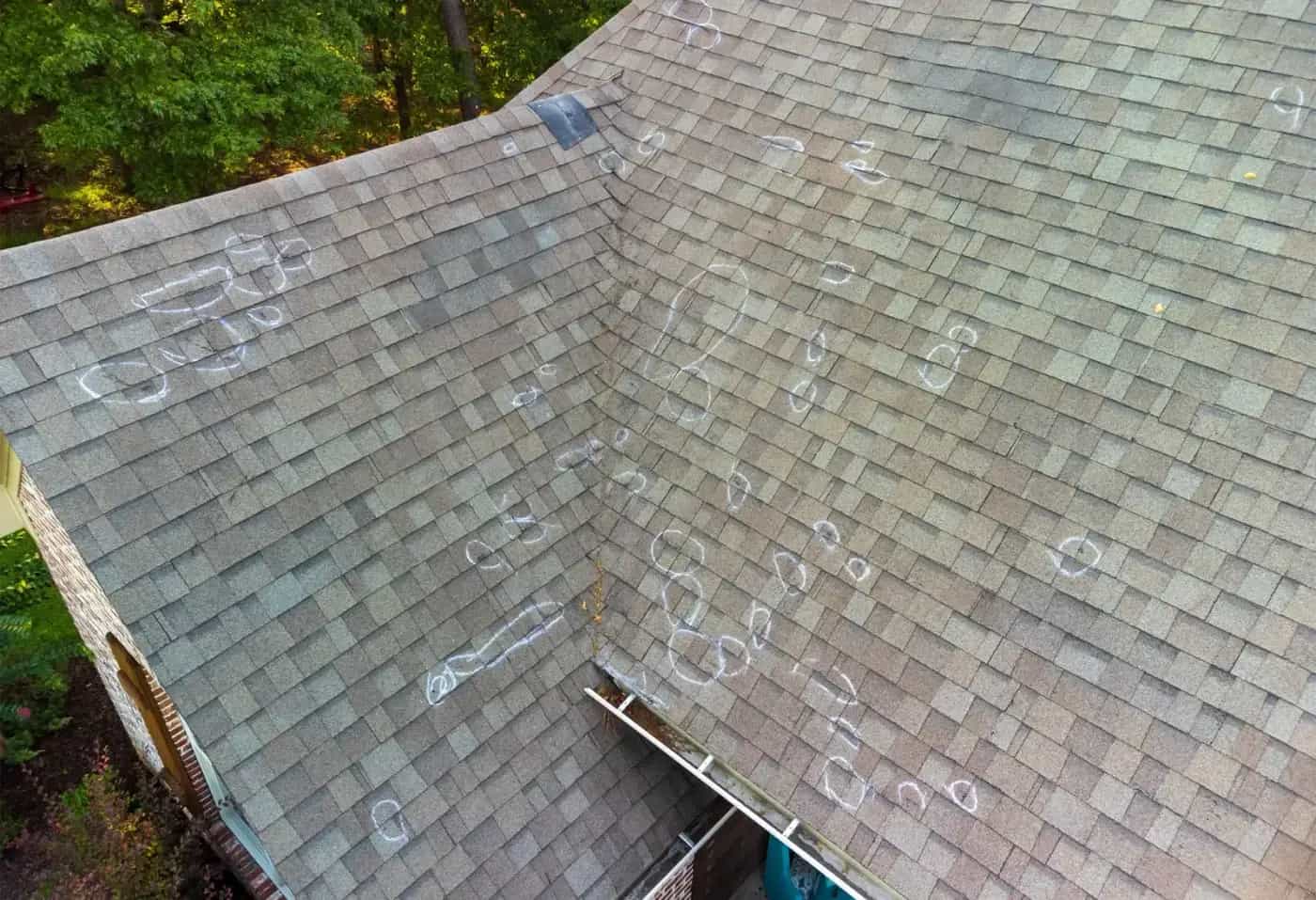 Storm damage on a Michigan roof showing missing shingles and wind damage Storm damage on a Michigan roof showing missing shingles and wind damage