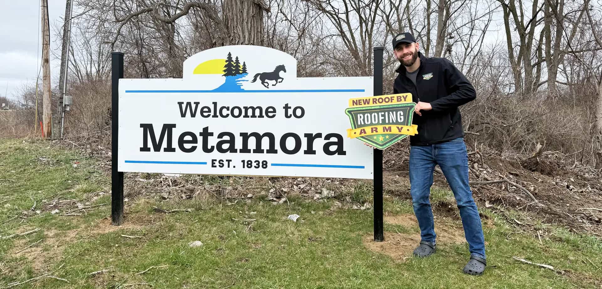 Aaron Scott, owner of Roofing Army, standing in front of the Metamora welcome sign in Metamora, Michigan Aaron Scott, owner of Roofing Army, standing in front of the Metamora welcome sign in Metamora, Michigan