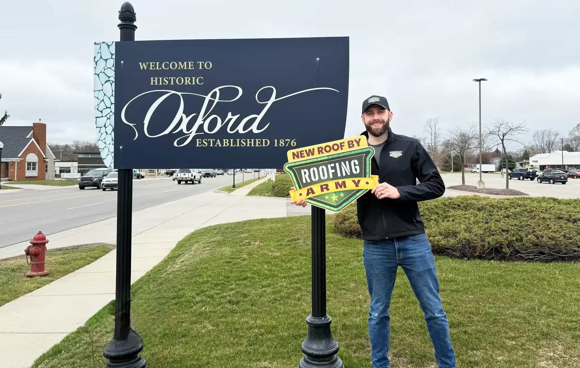 Aaron Scott, owner of Roofing Army, standing in front of the Welcome to Historic Oxford sign in Oxford, Michigan Aaron Scott, owner of Roofing Army, standing in front of the Welcome to Historic Oxford sign in Oxford, Michigan