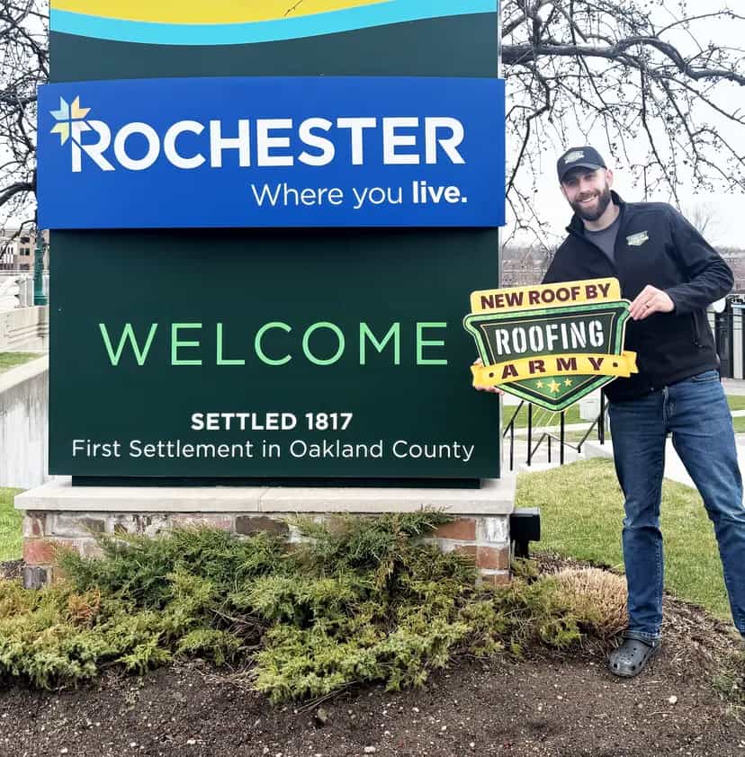 Aaron Scott, owner of Roofing Army, standing in front of the Rochester welcome sign in Rochester, Michigan Aaron Scott, owner of Roofing Army, standing in front of the Rochester welcome sign in Rochester, Michigan