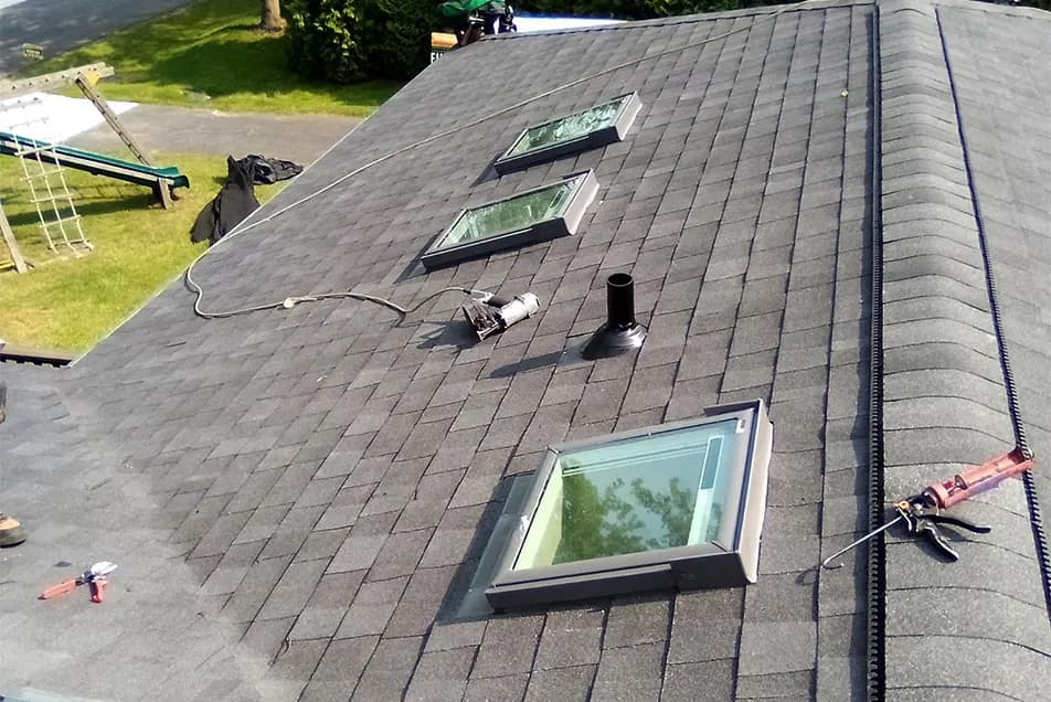 three velux skylights on an asphalt shingle roof