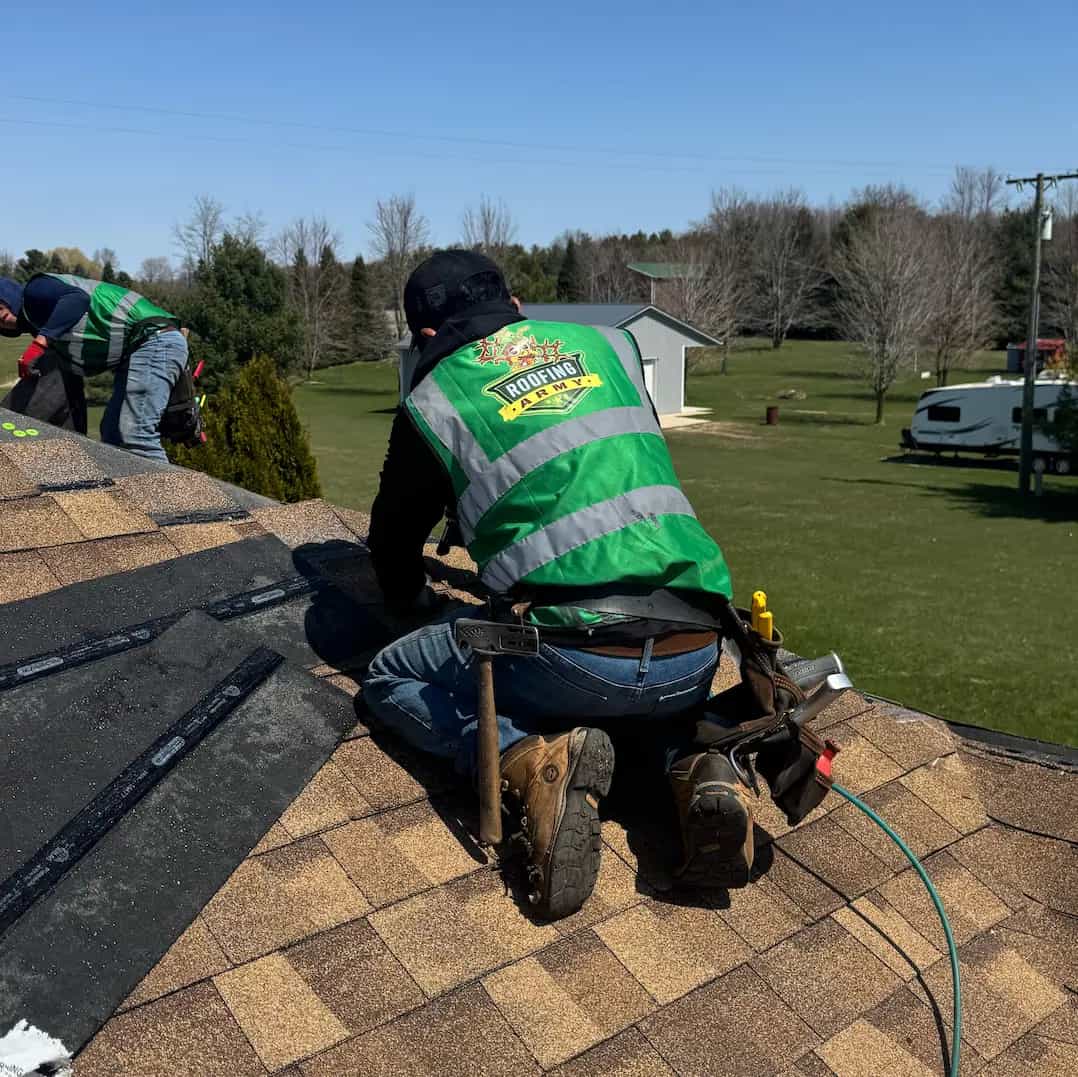 Why Choose Roofing Army - SE Michigan Roofing Contractor roofer wearing a green roofing army construction vest nailing hip shingles on a roof